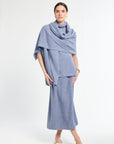 Woman wearing a light blue outfit with a matching scarf on a white background