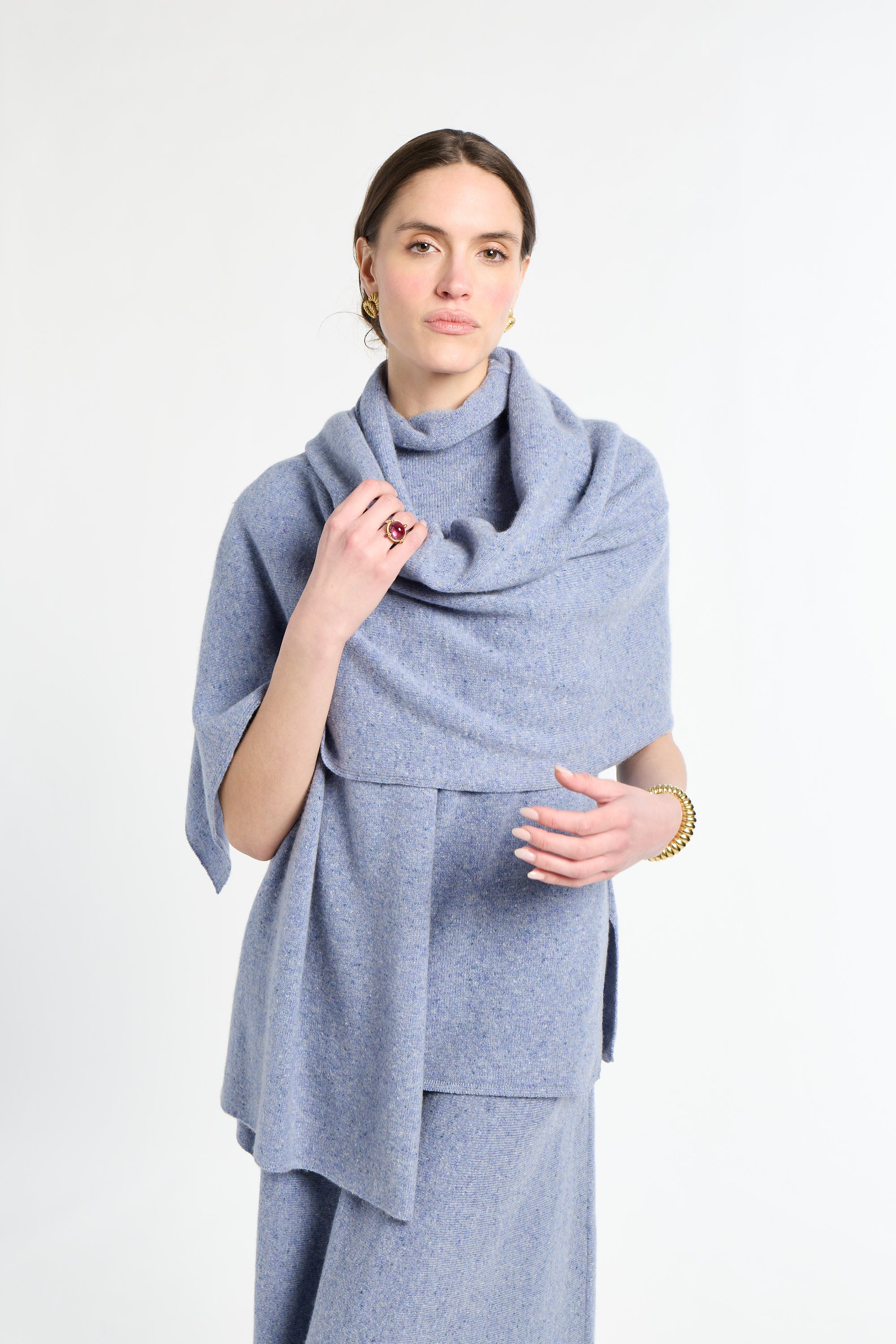 Woman wearing a light blue scarf and dress against a white background