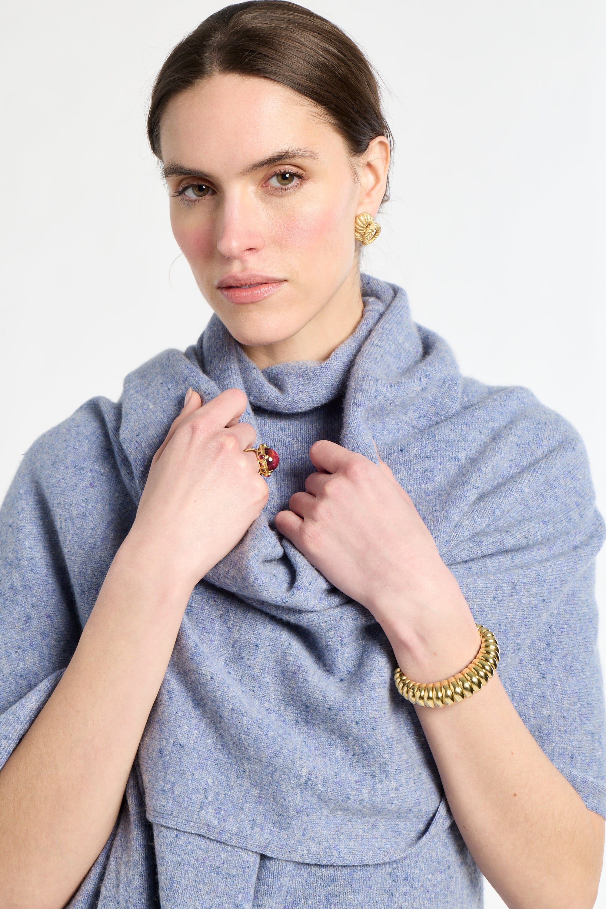 Woman wearing a blue scarf with jewelry on a white background