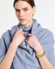Woman wearing a blue scarf with jewelry on a white background