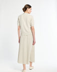 Woman wearing a beige dress with a plain white background