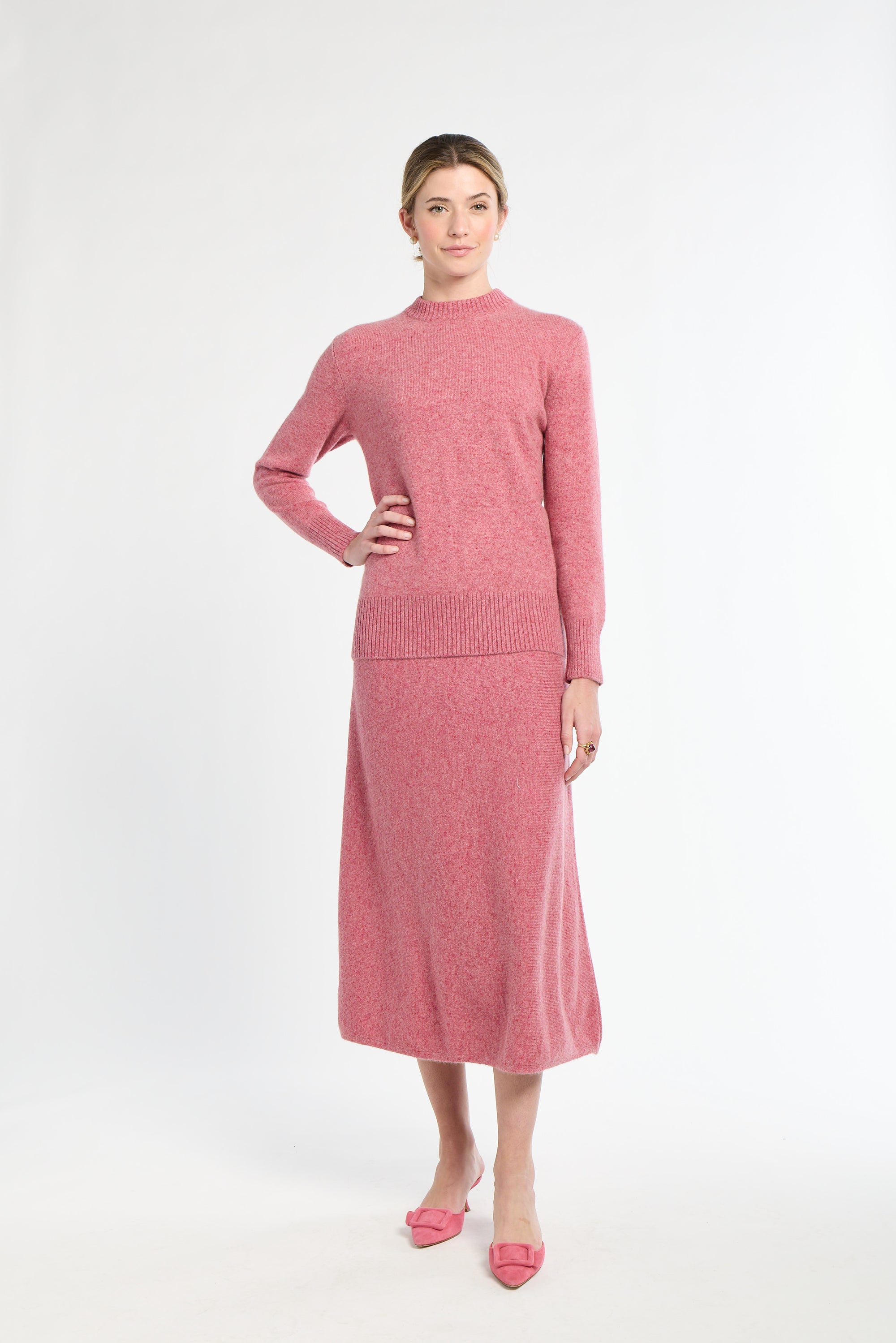 Woman wearing a pink knit outfit on a white background