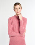 Woman wearing a pink sweater and skirt on a white background