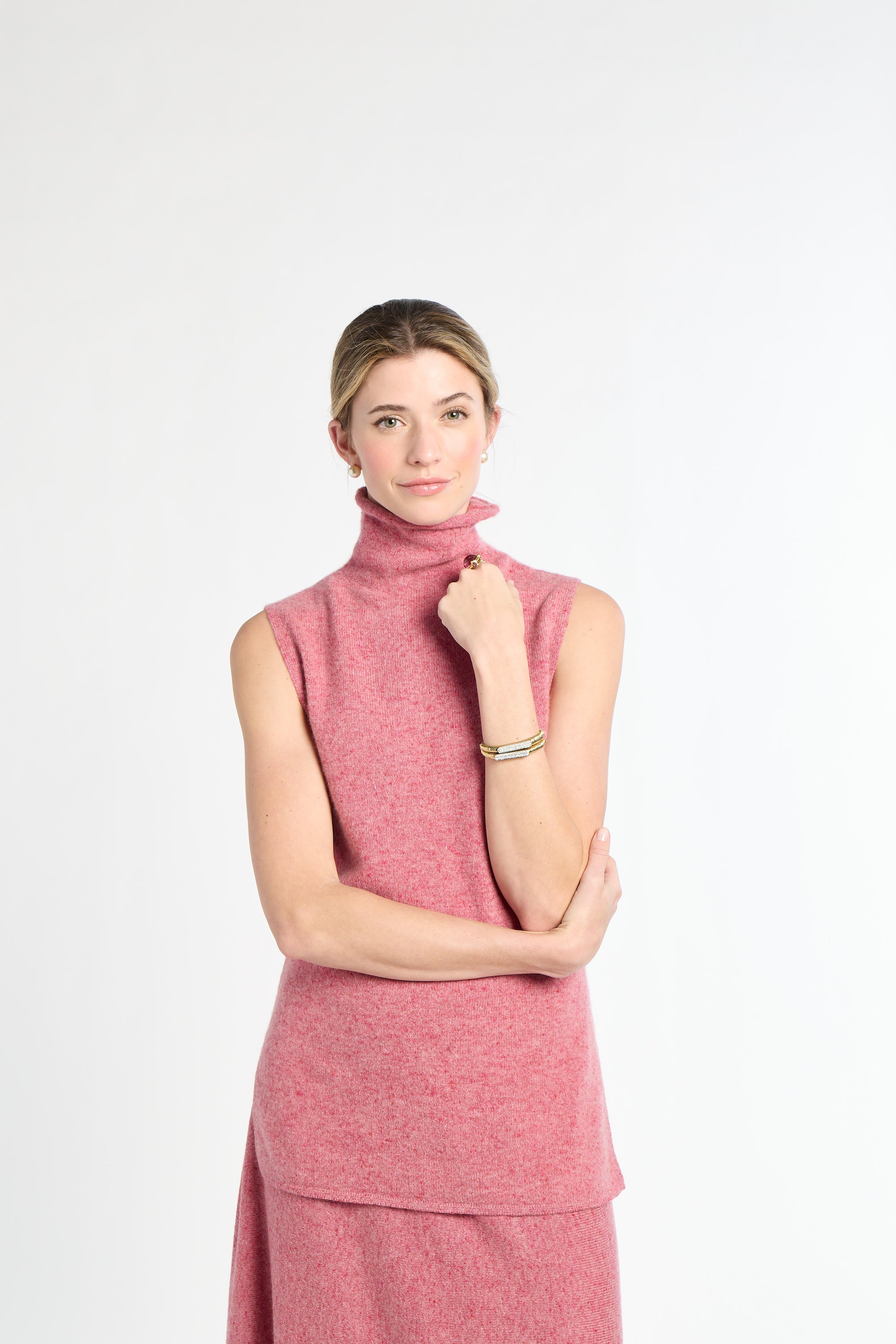 Woman wearing a pink sleeveless top with a white background