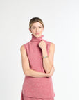 Woman wearing a pink sleeveless top with a white background