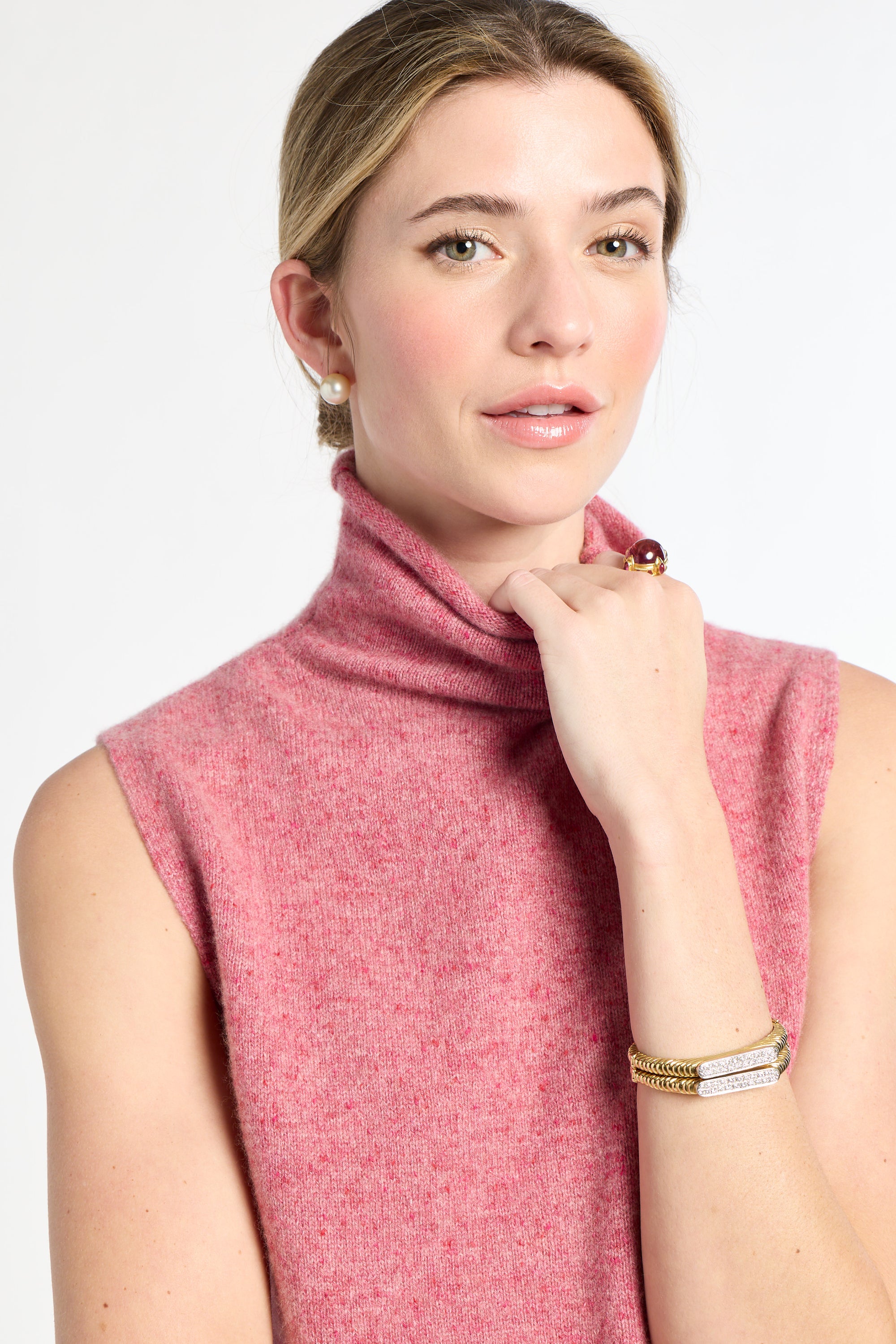 Woman wearing a pink sleeveless top against a white background