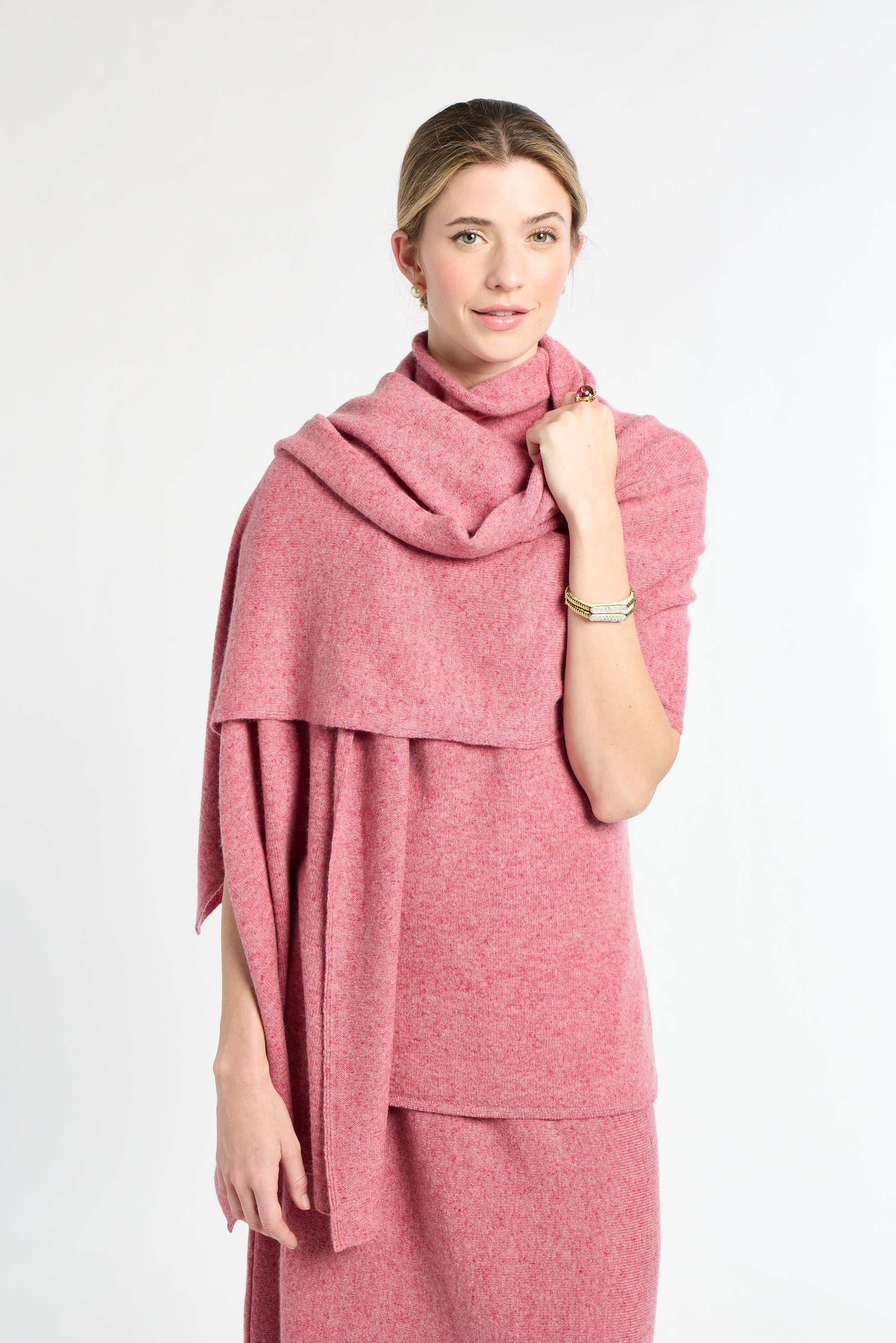 Woman wearing a pink scarf and dress against a white background