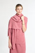Woman wearing a pink scarf and dress against a white background