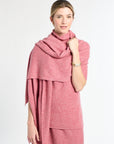 Woman wearing a pink scarf and dress against a white background