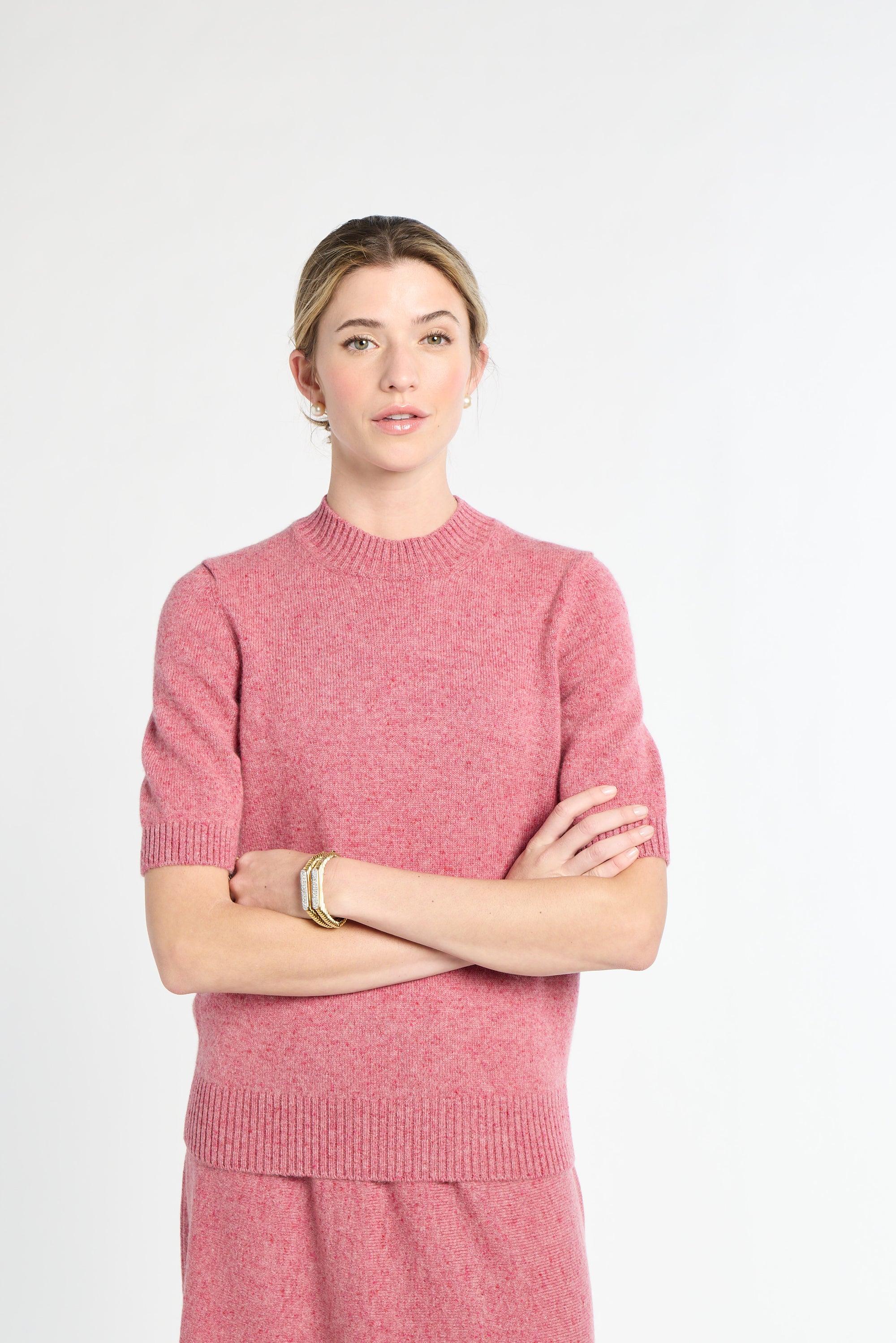 Woman wearing a pink sweater against a white background