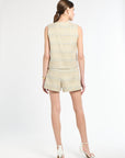 Back of woman wearing a golden and light blue tweed shirt with matching shorts on a white background