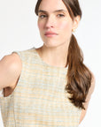 Woman wearing a sleeveless tweed shirt on a white background