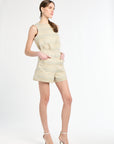 Woman wearing a tweed light-colored sleeveless top and shorts set on a white background