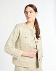 Woman wearing a golden and light blue blazer and shorts set on a white background