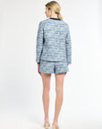 Back of a woman wearing blue tweed blazer and matching shorts on a white background