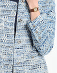 Close-up of a person wearing a blue tweed jacket with a watch on a white background