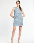 Woman wearing a blue tweed dress on a white background