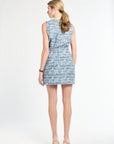 Back of a woman wearing a matching blue tweed top and skirt on a white background