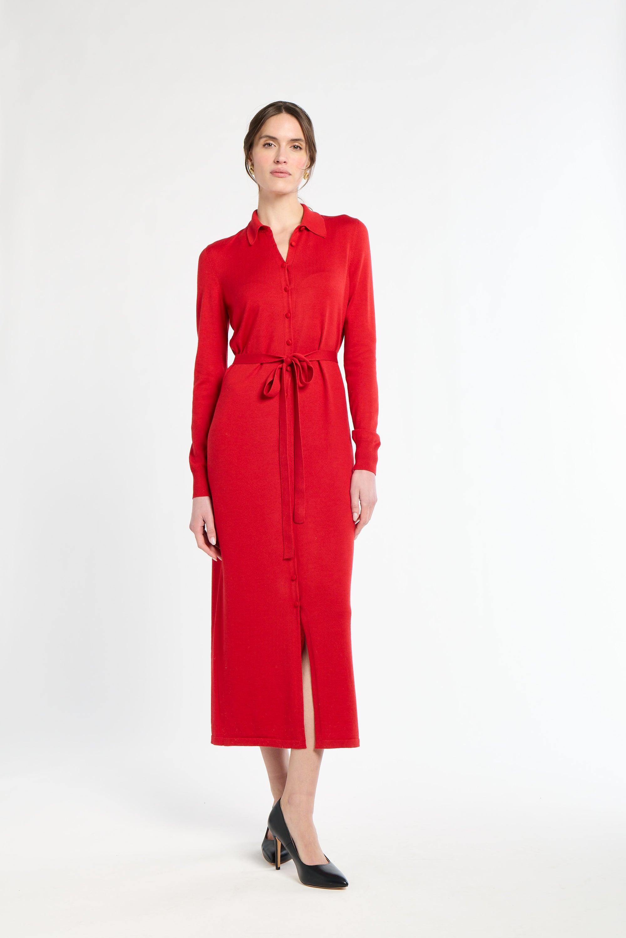 Woman wearing a red dress with a belt on a white background