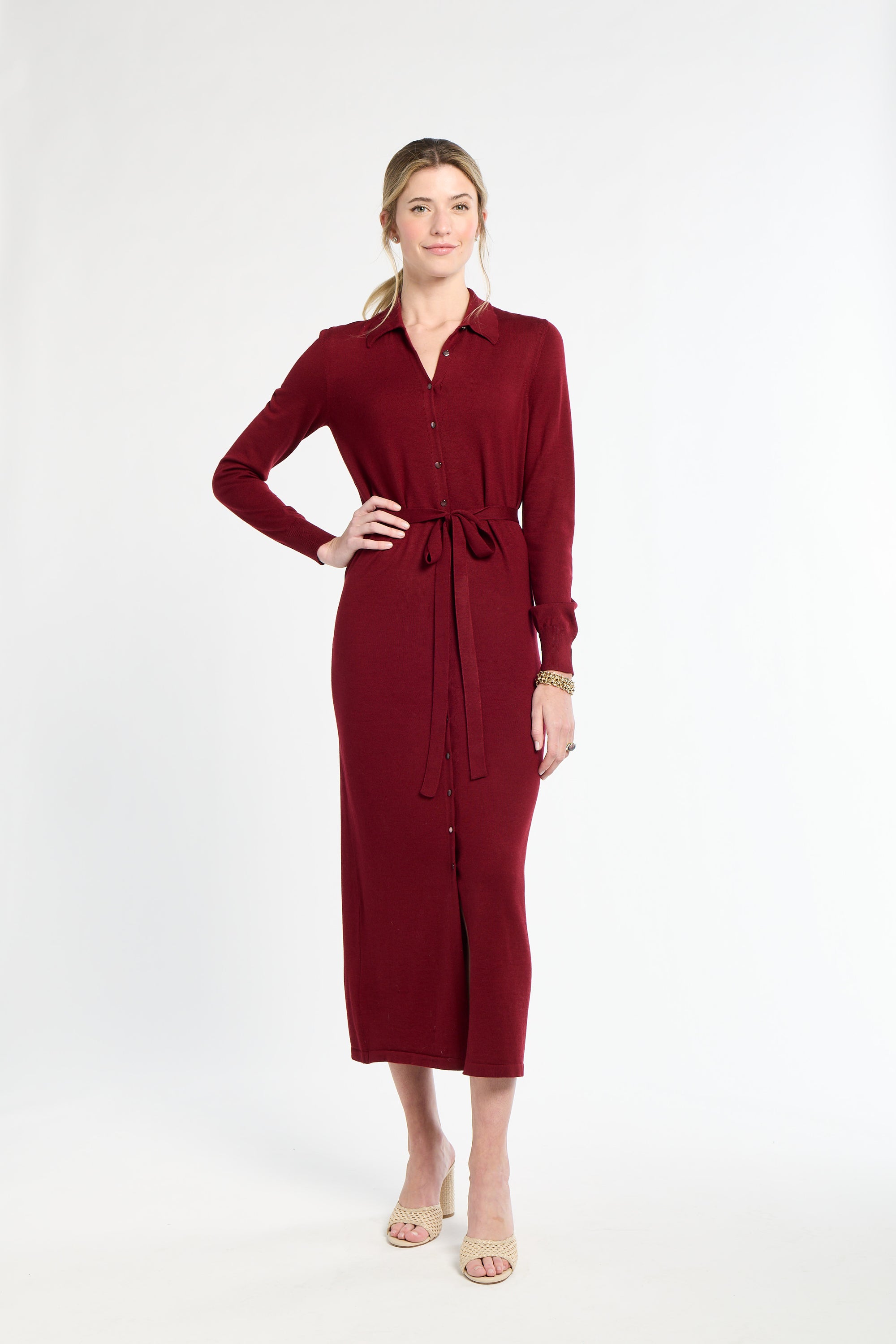 Woman wearing a burgundy dress with a belt on a white background