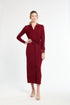 Woman wearing a burgundy dress with a belt on a white background