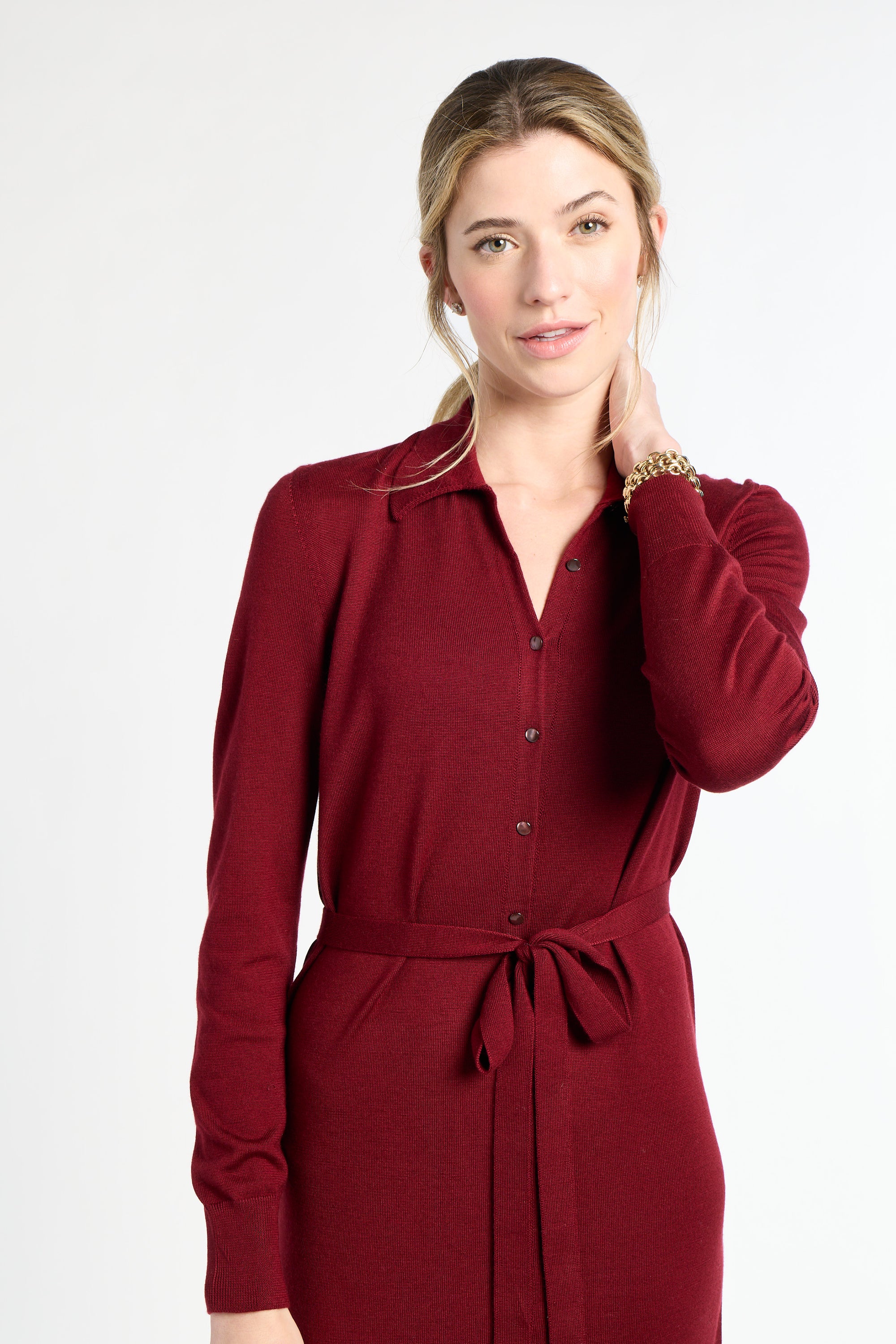 Woman wearing a red dress with a belt on a white background