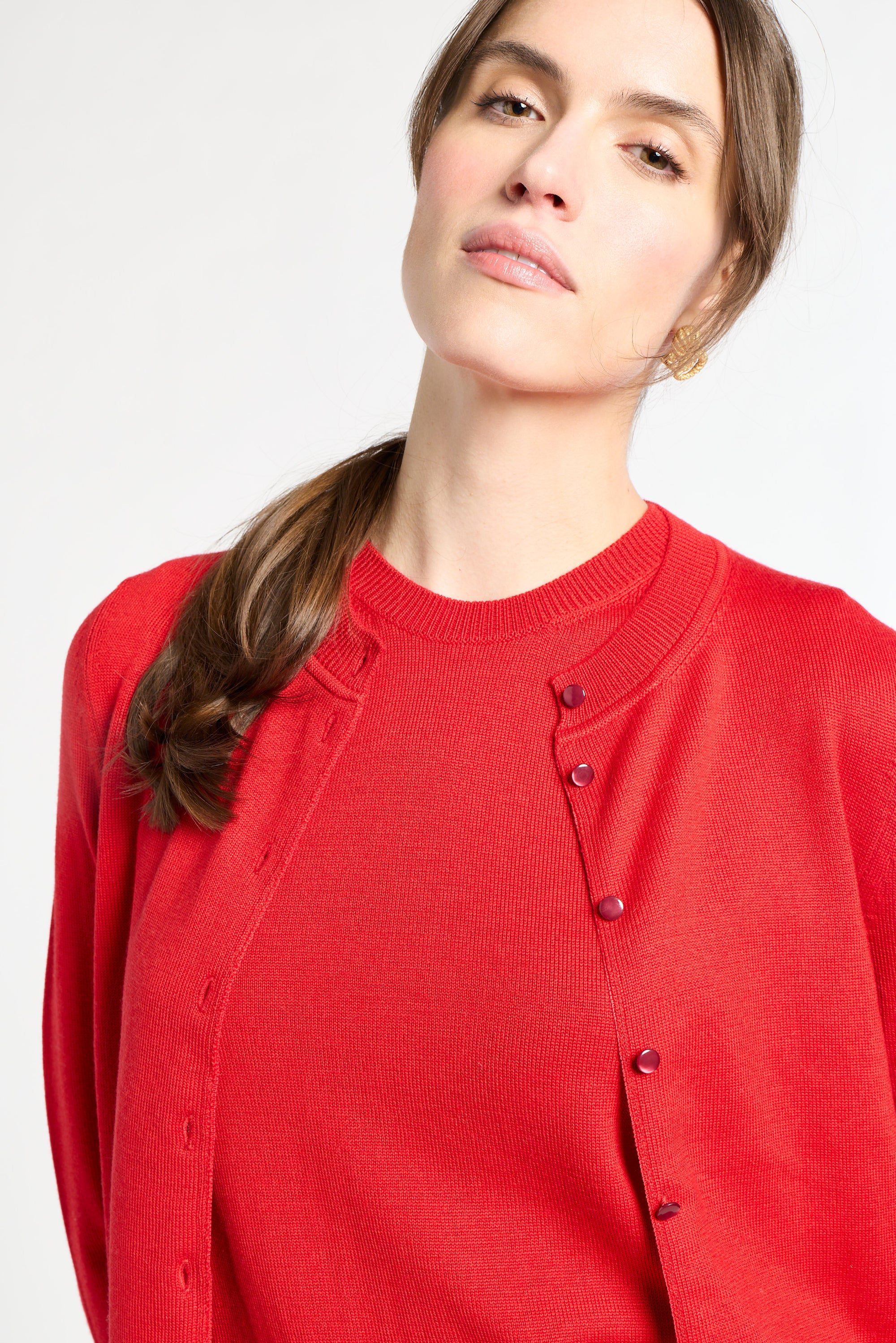 Woman wearing a red cardigan on a white background