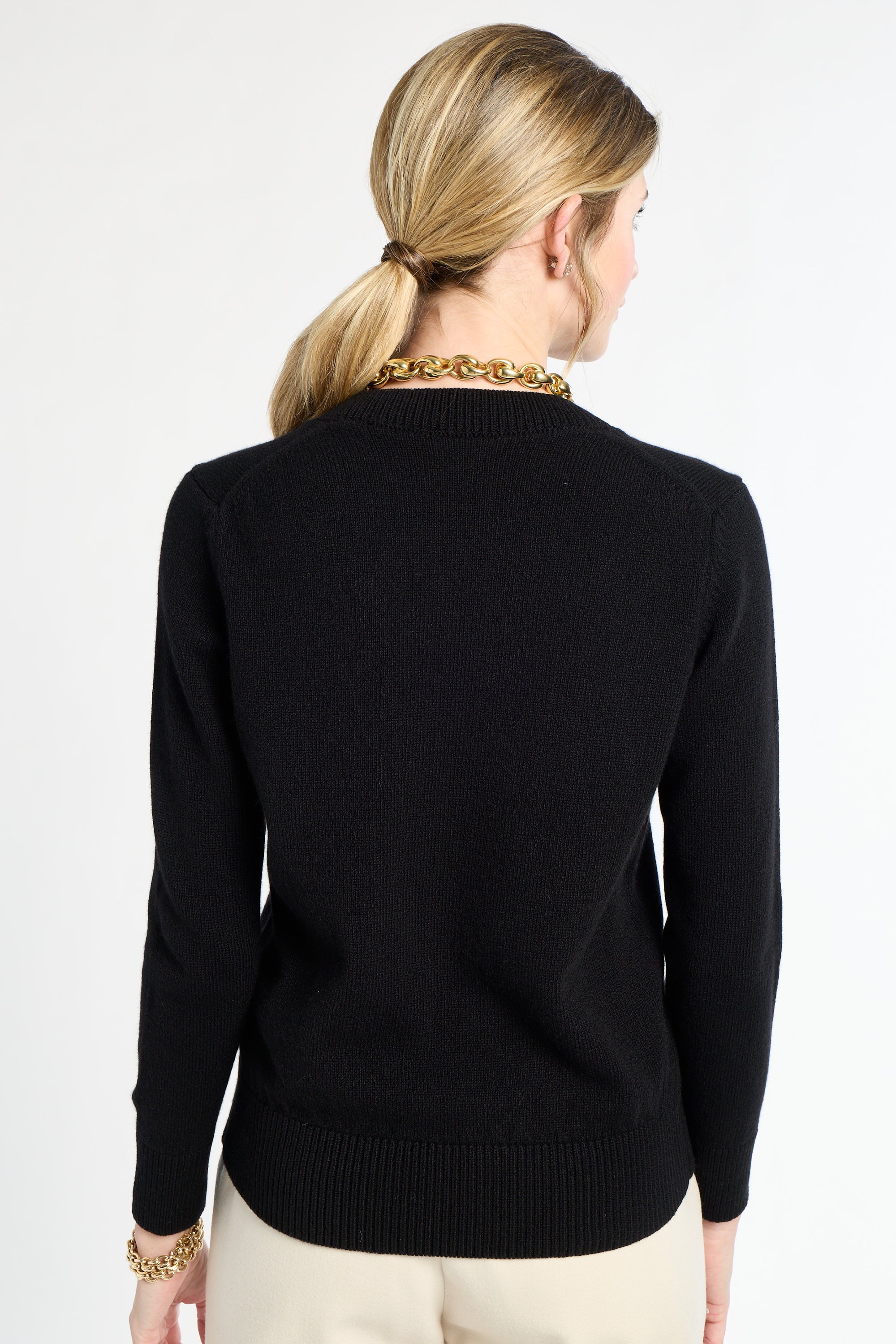 Person wearing a black sweater on a white background