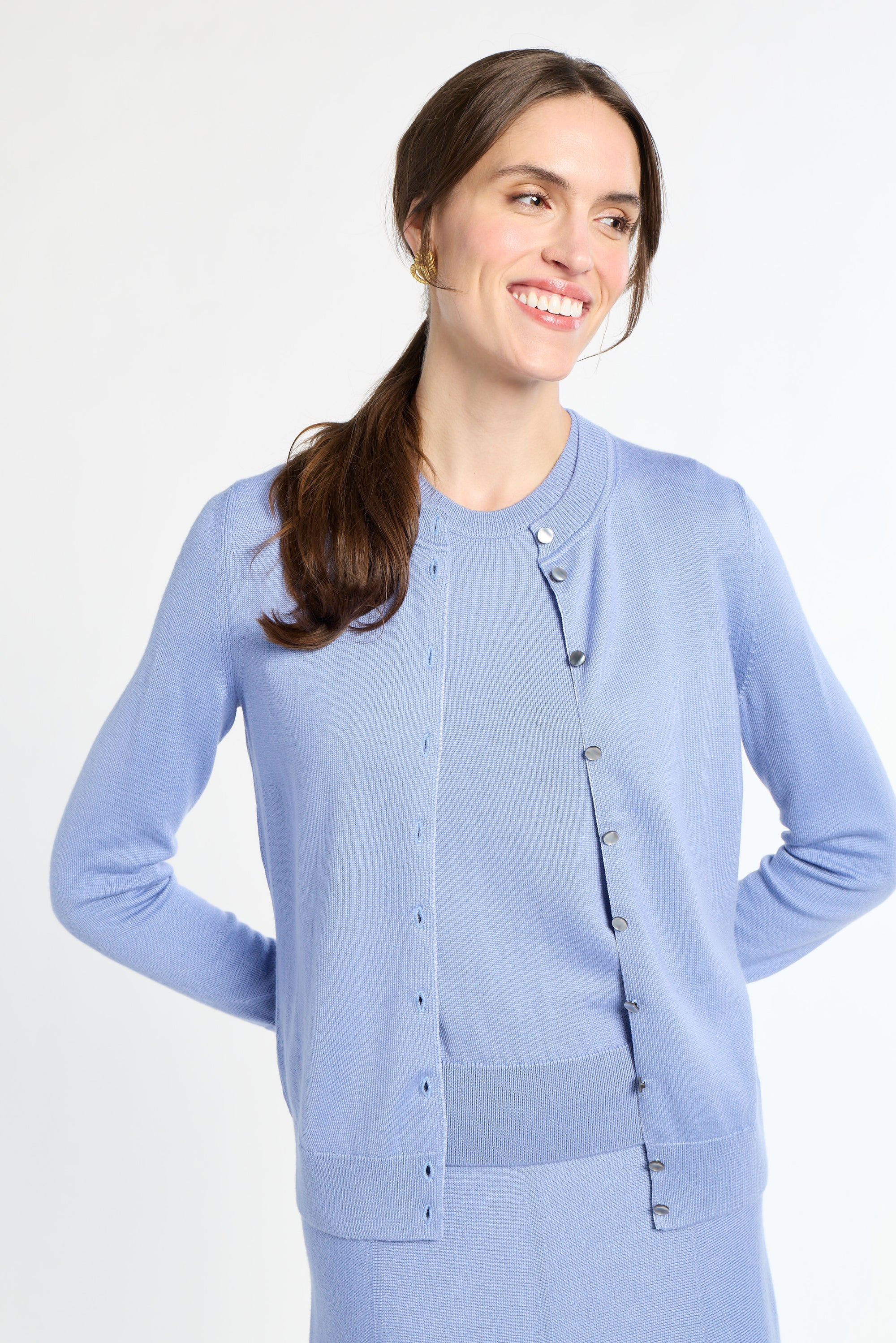 Woman wearing a light blue cardigan on a white background