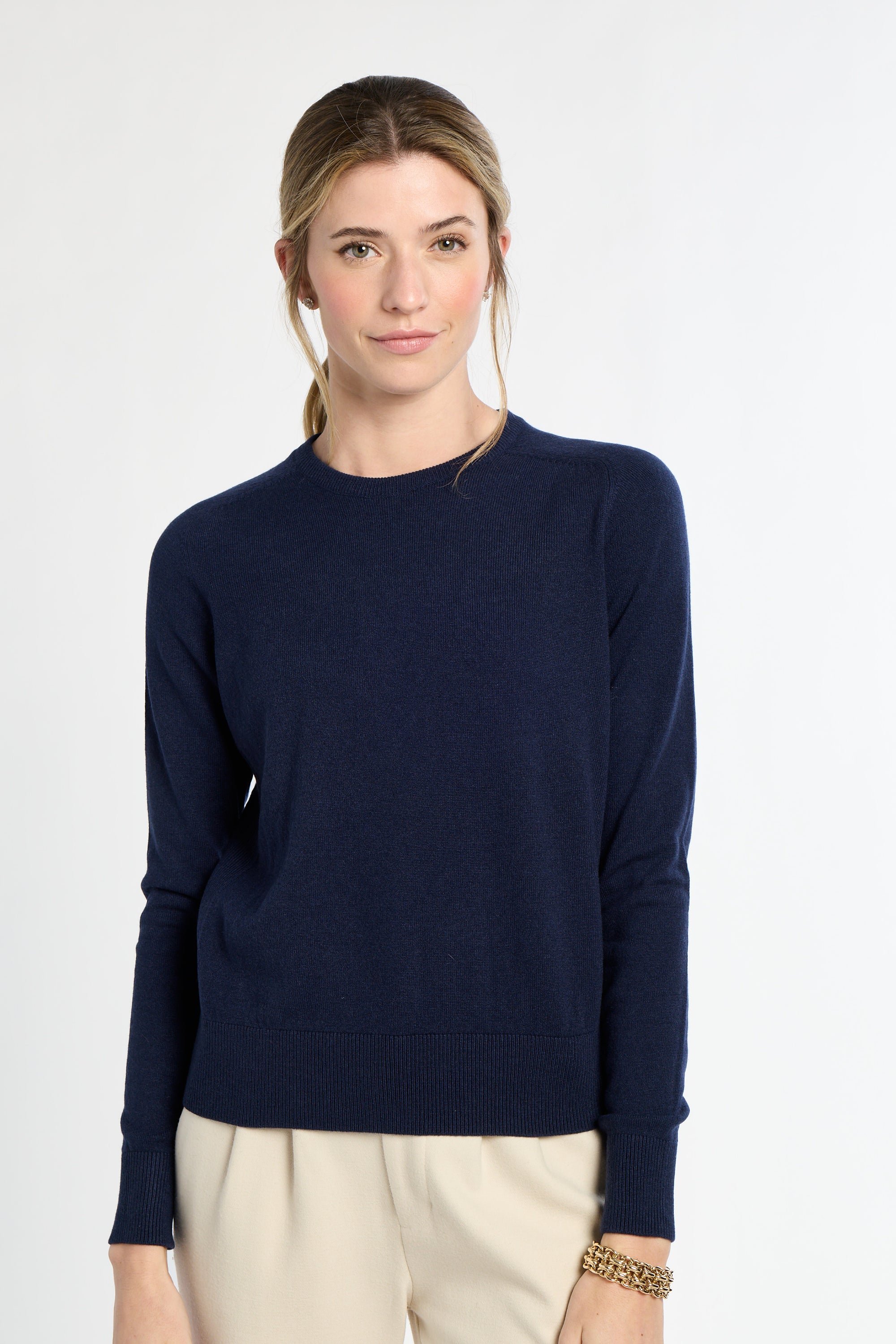 Woman wearing a navy blue sweater on a white background