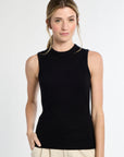 Woman wearing a black sleeveless top against a white background