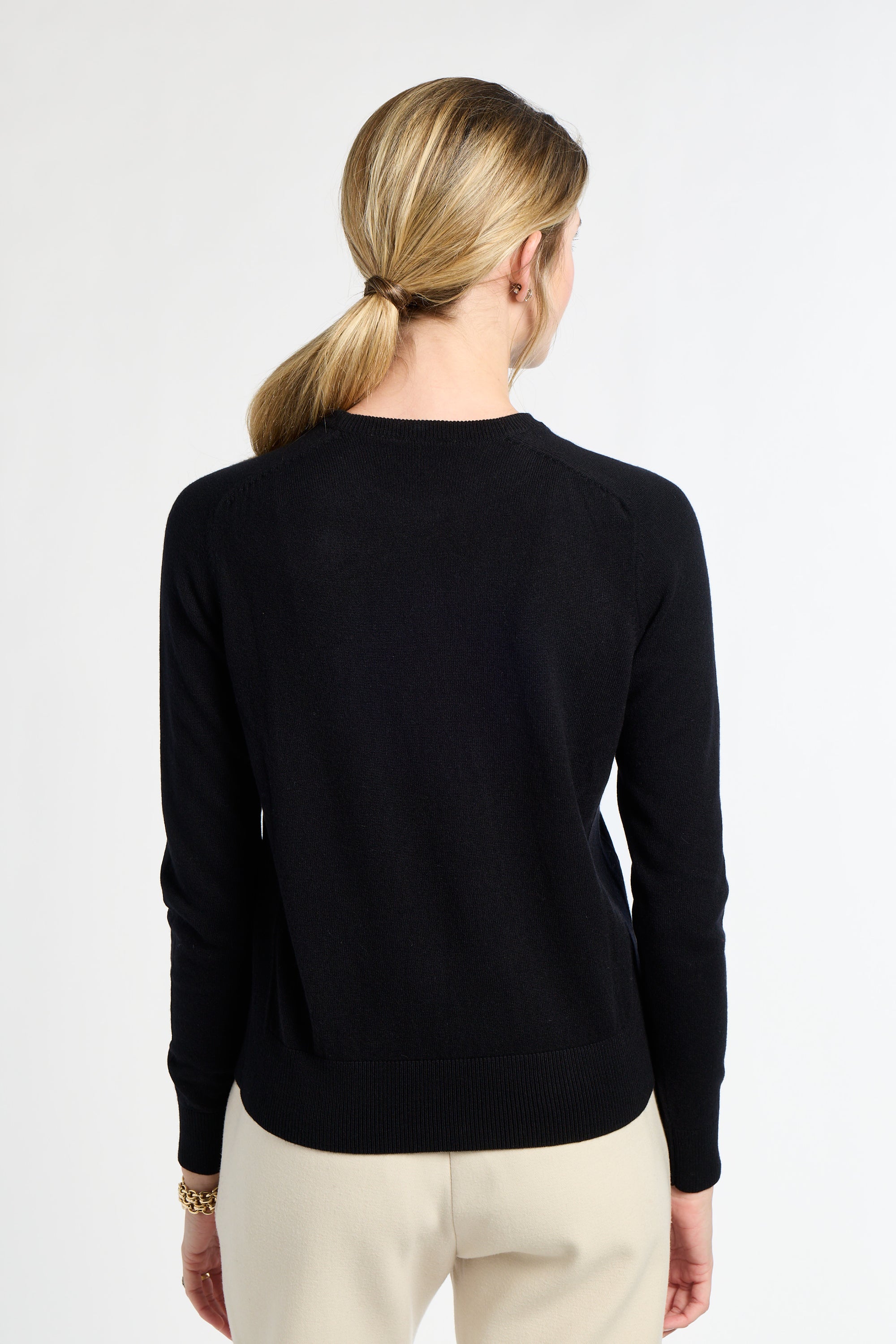 Person wearing a black sweater on a white background