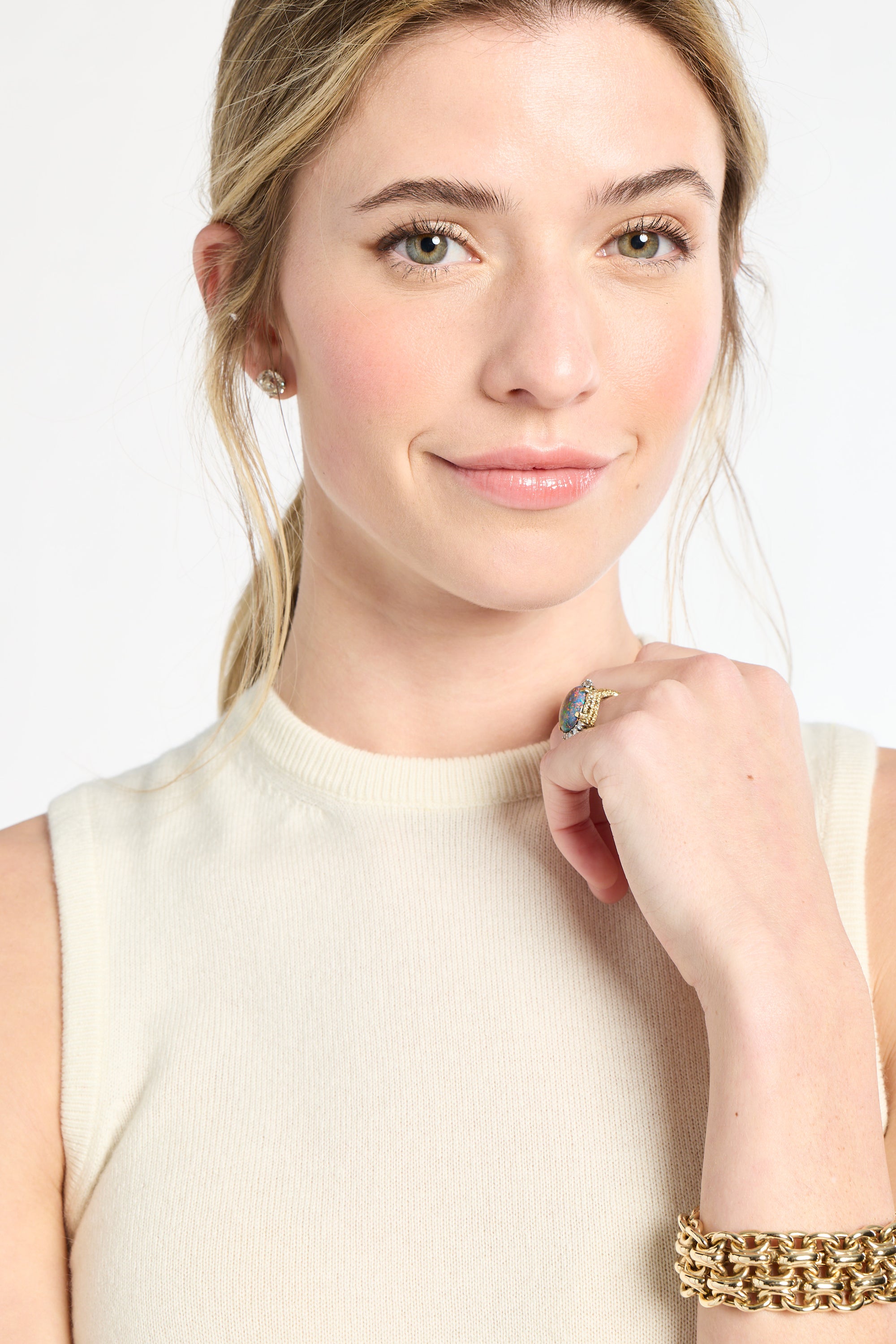 Woman wearing a gold bracelet on a white background