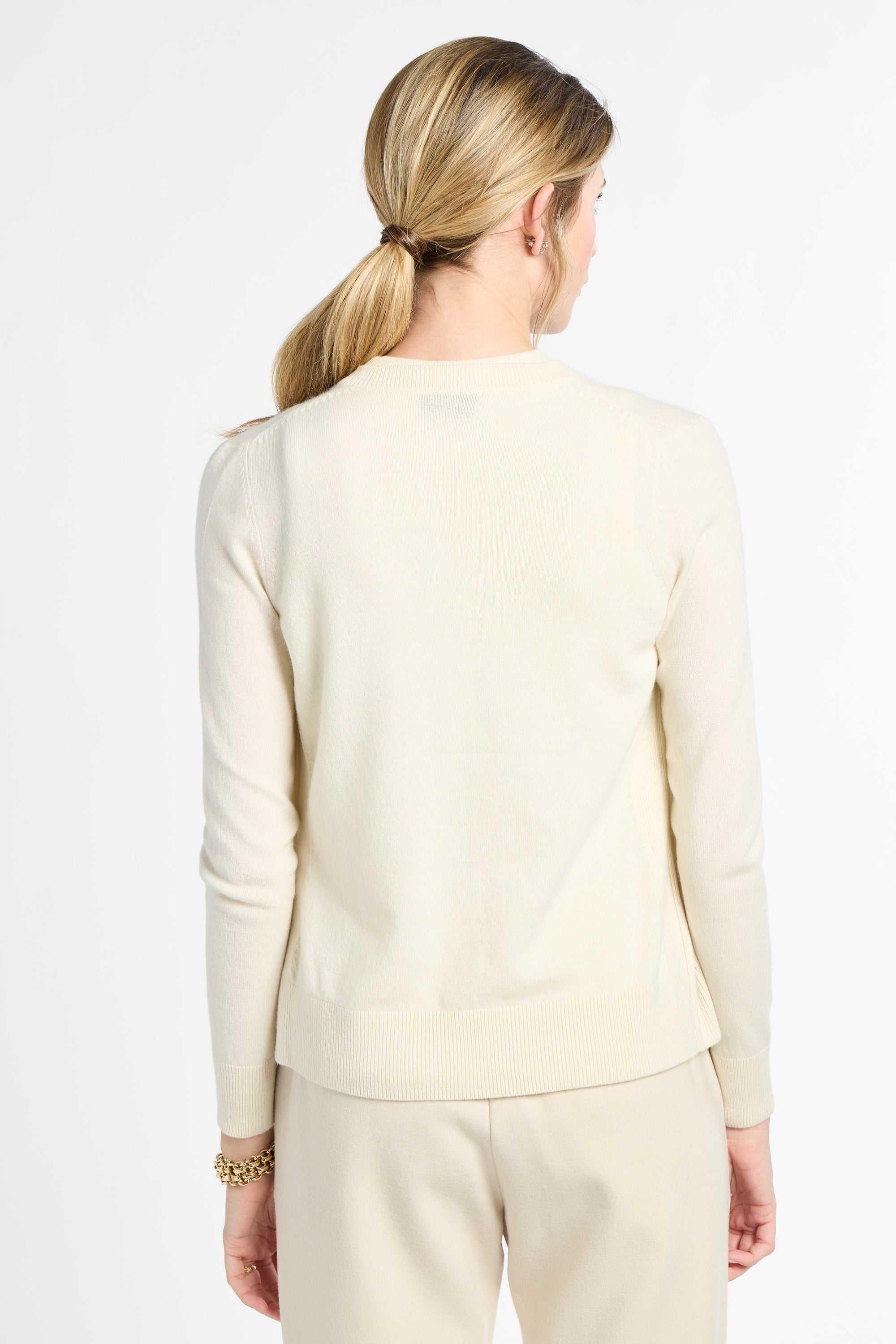 Woman wearing a cream-colored suit on a white background
