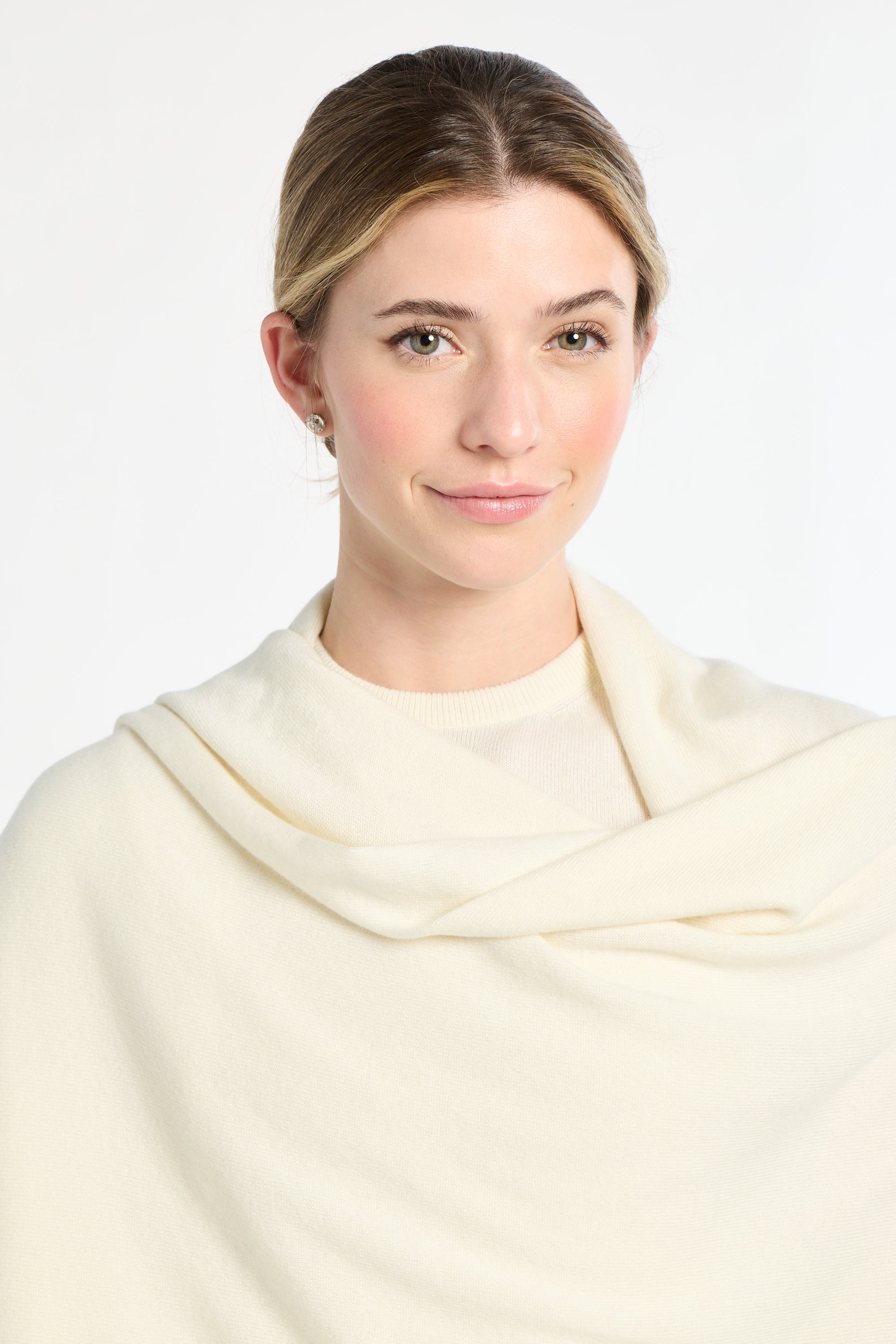 Woman wearing a cream-colored scarf against a white background
