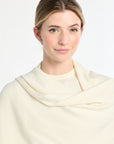 Woman wearing a cream-colored scarf against a white background