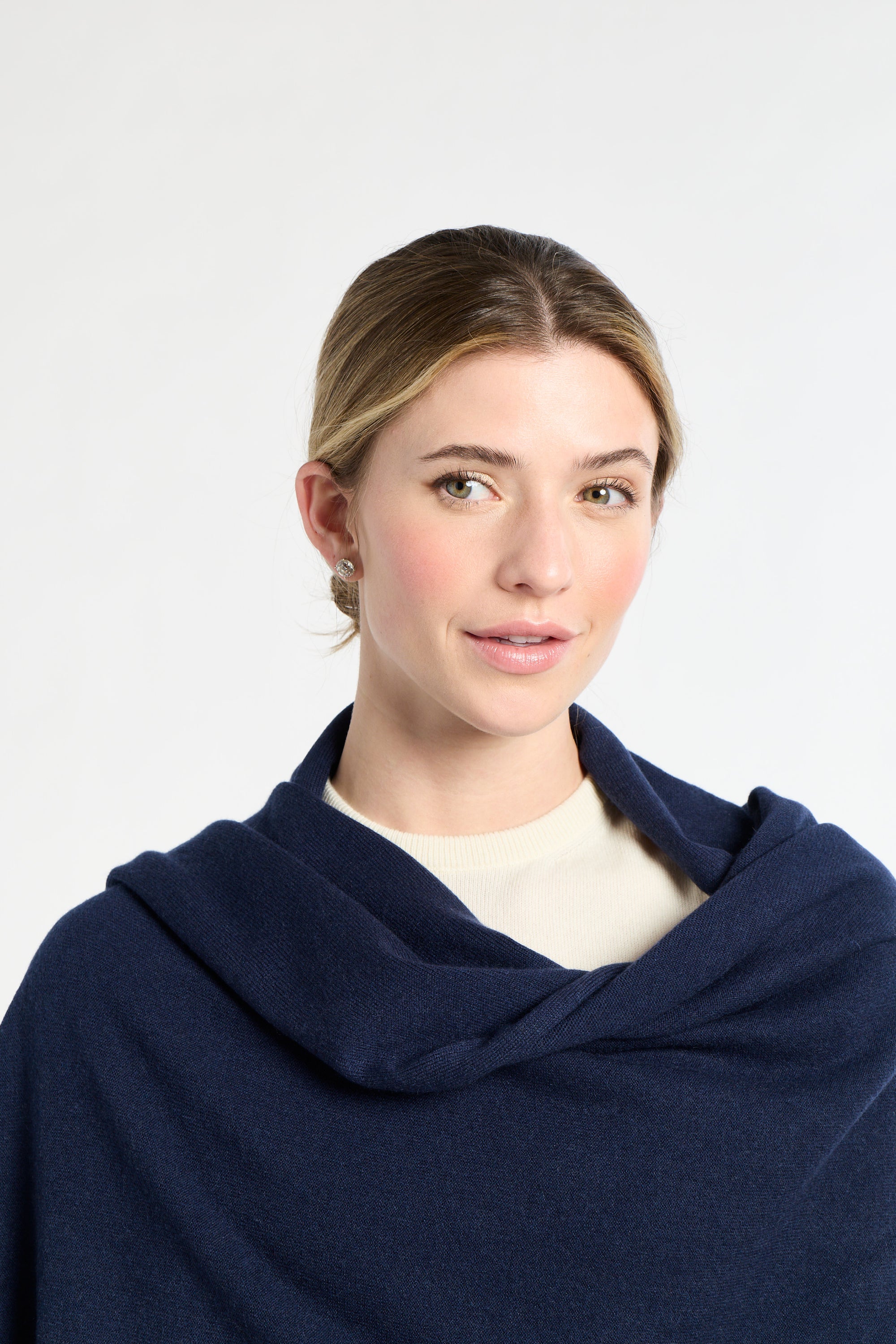 Woman wearing a navy blue shawl against a white background