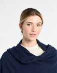 Woman wearing a navy blue shawl against a white background
