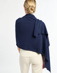 Person wearing a navy blue shawl over shoulders on a white background