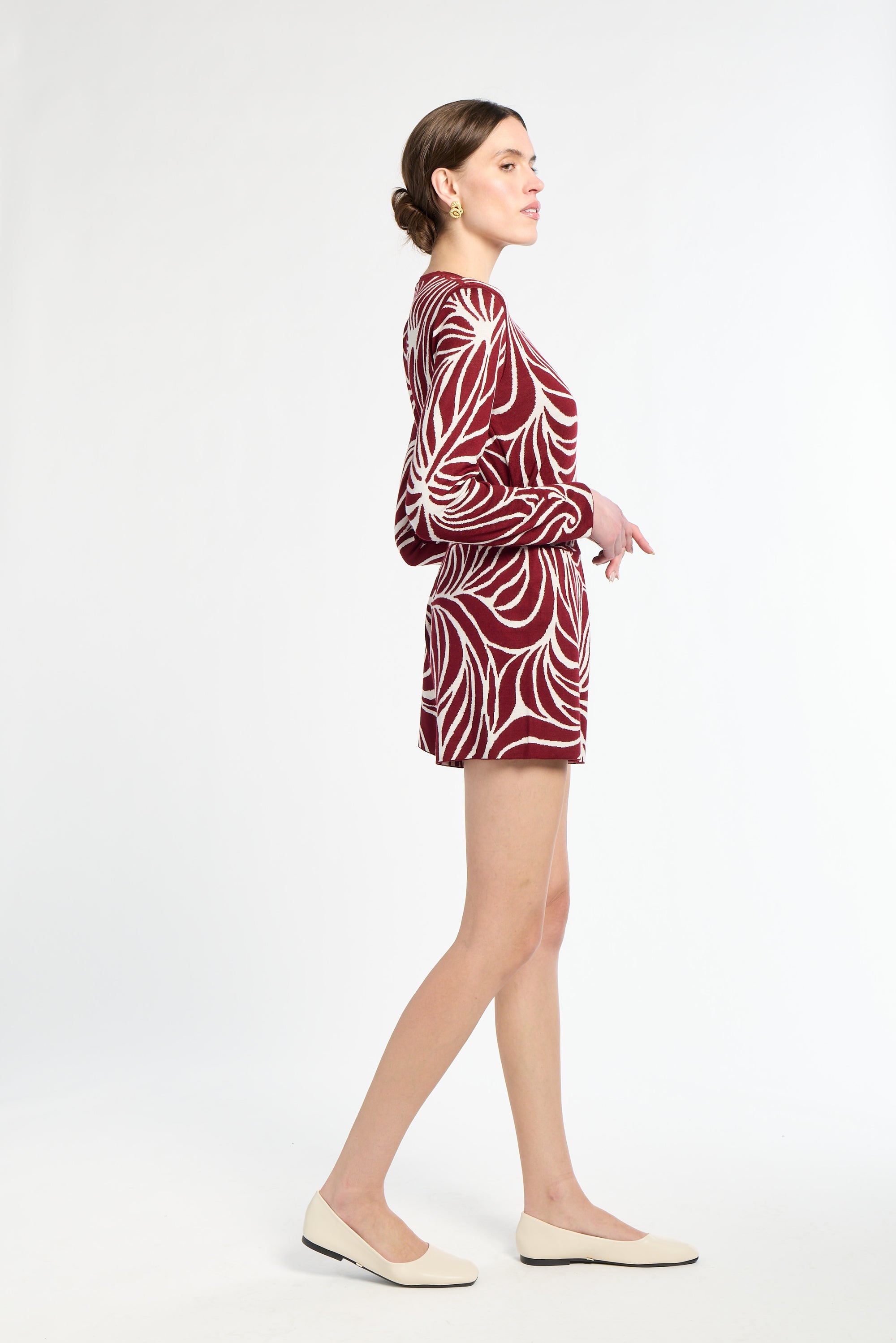 Woman wearing a red and white patterned outfit on a white background