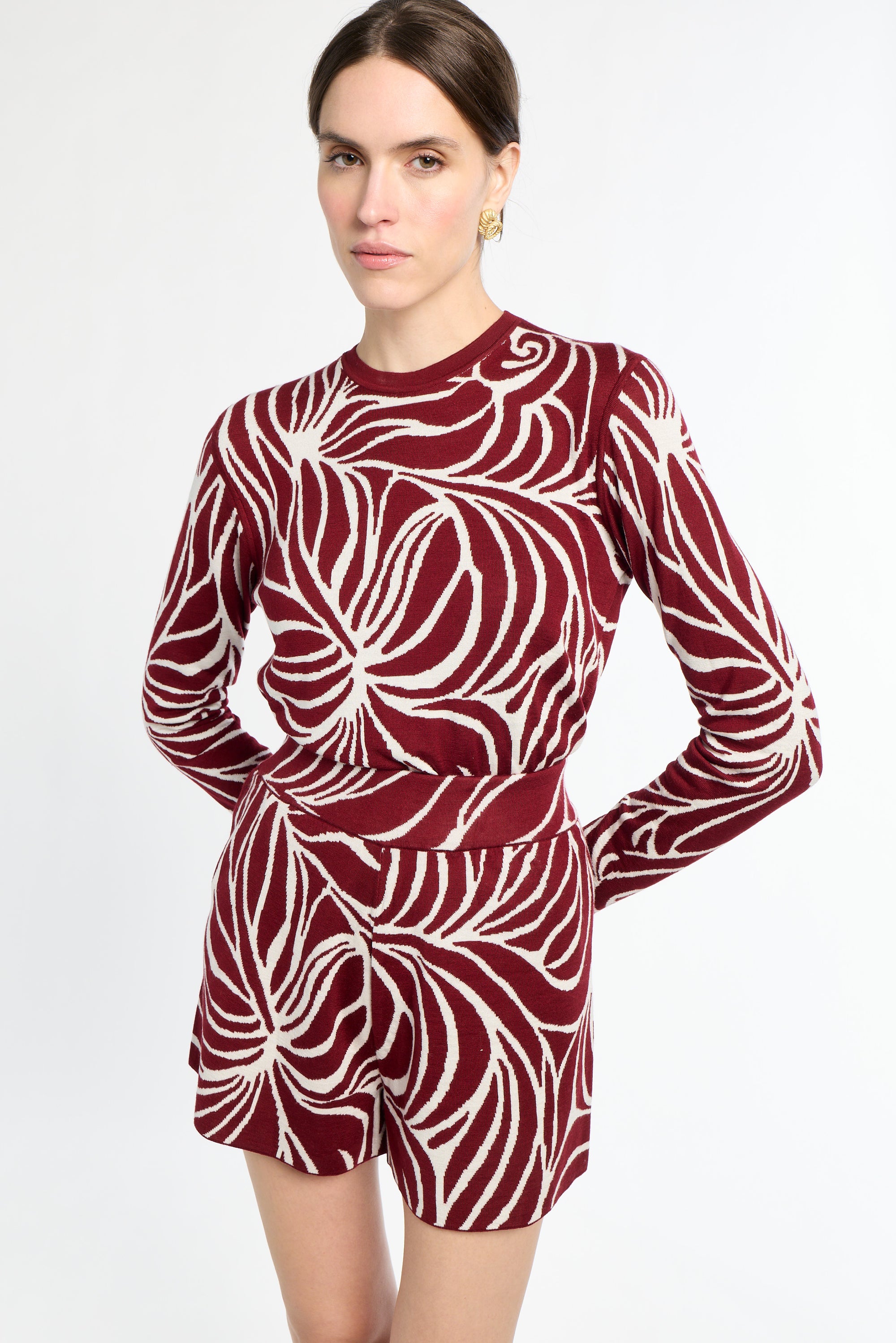 Woman wearing a red and white patterned dress on a white background