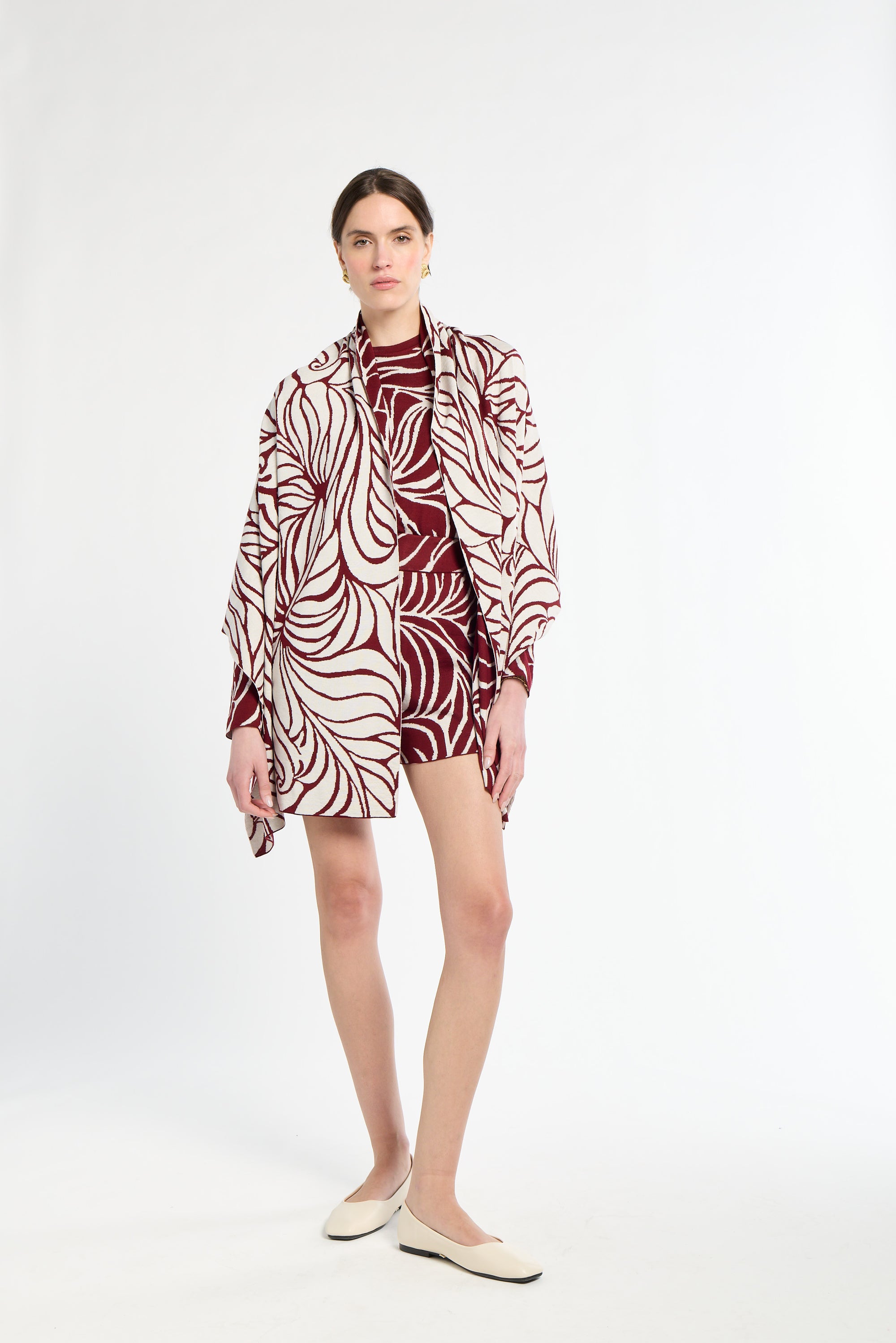 Woman wearing a patterned outfit on a white background