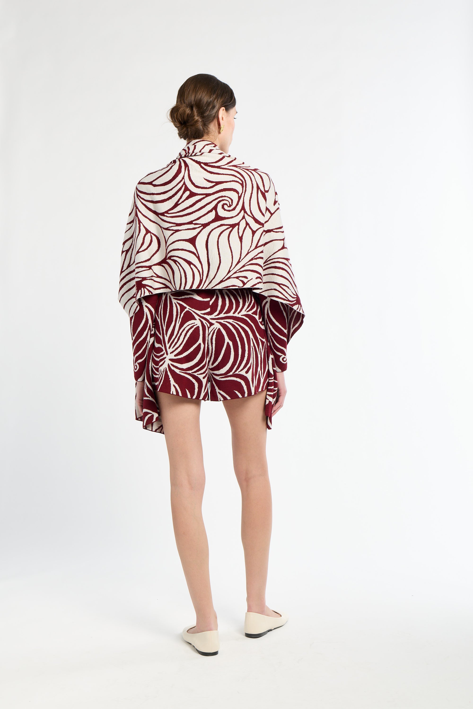 Person wearing a patterned outfit with a white background