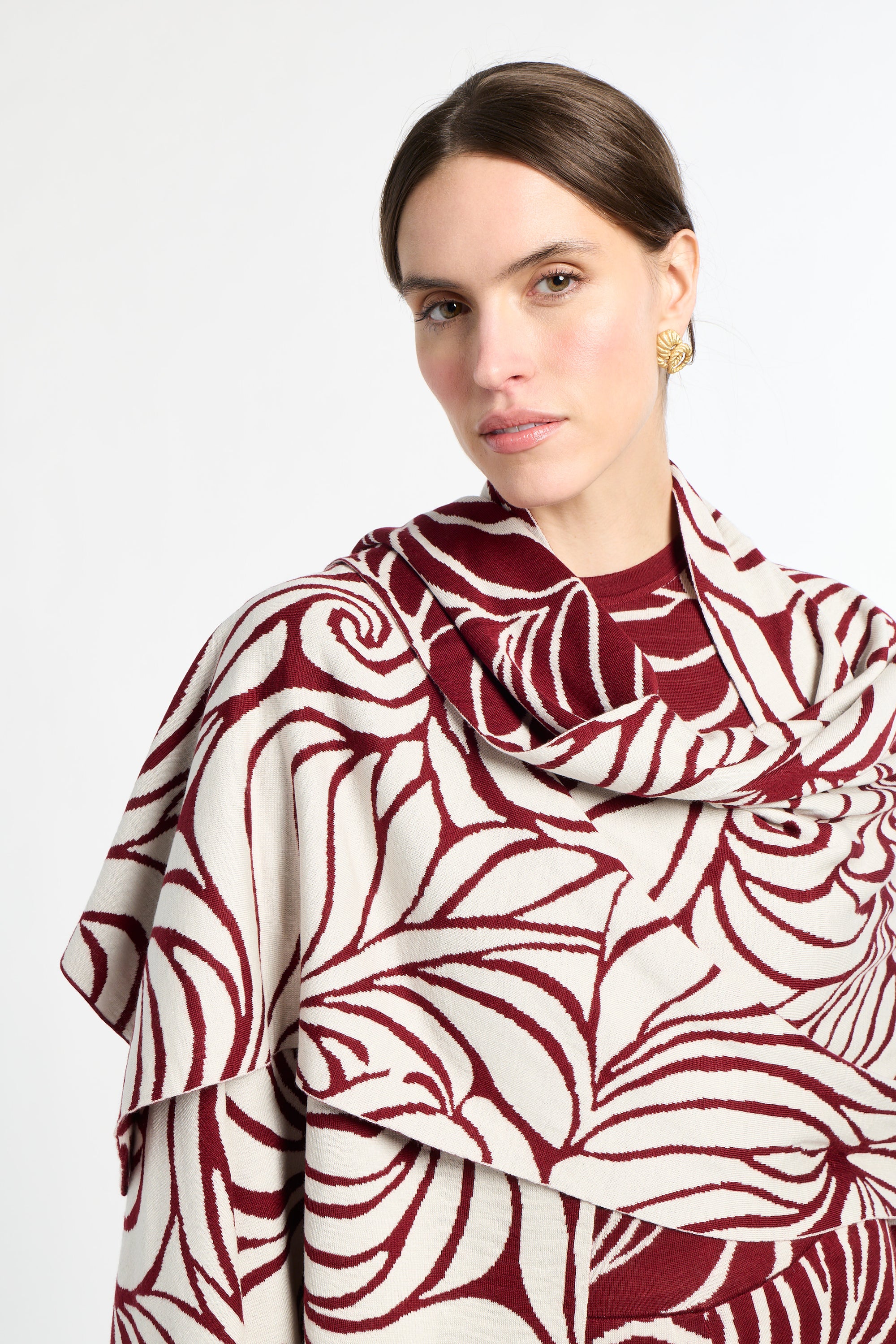 Woman wearing a red and white patterned scarf on a white background