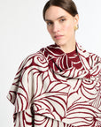 Woman wearing a red and white patterned scarf on a white background