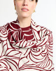 Woman wearing a red and white patterned scarf on a white background