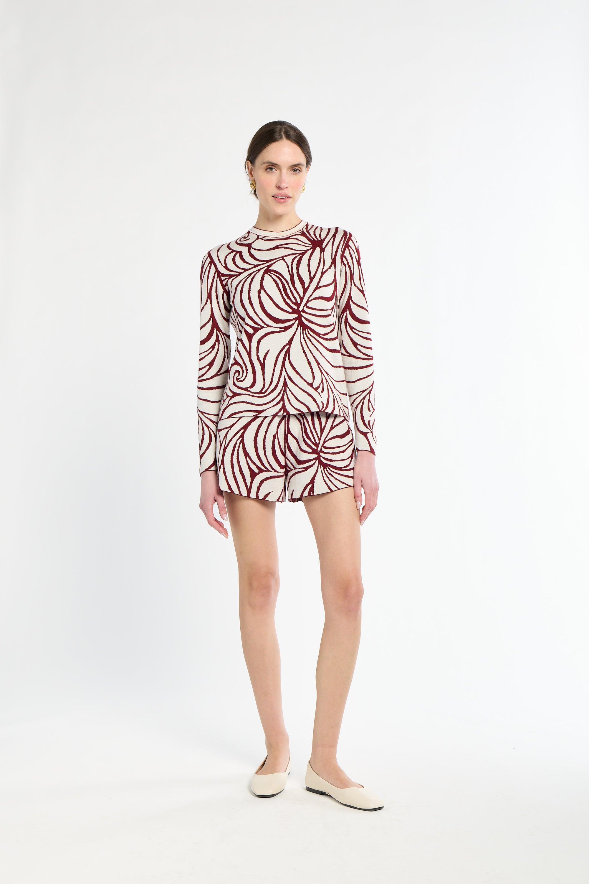 Woman wearing a patterned dress on a white background