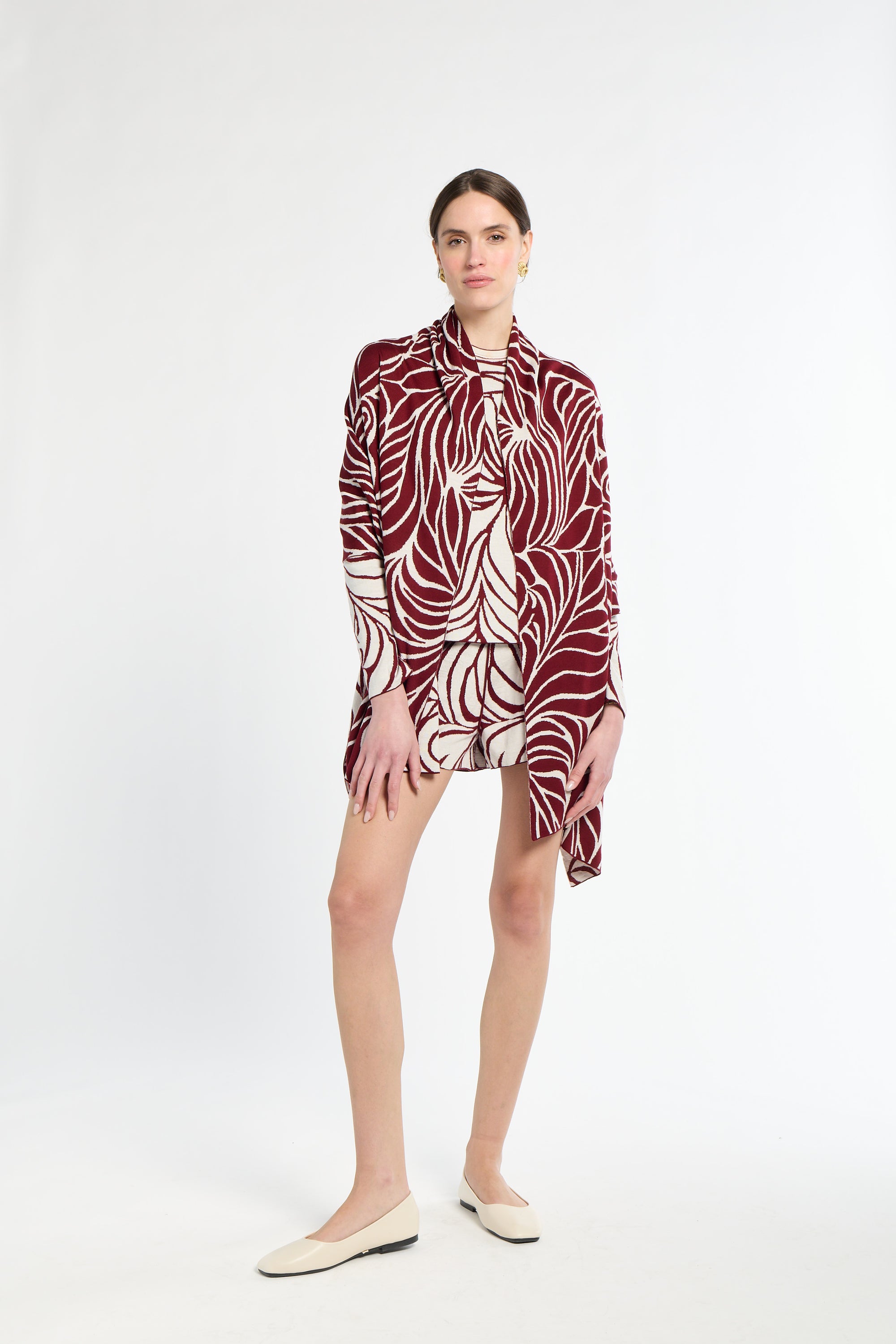 Woman wearing a patterned dress with a white background