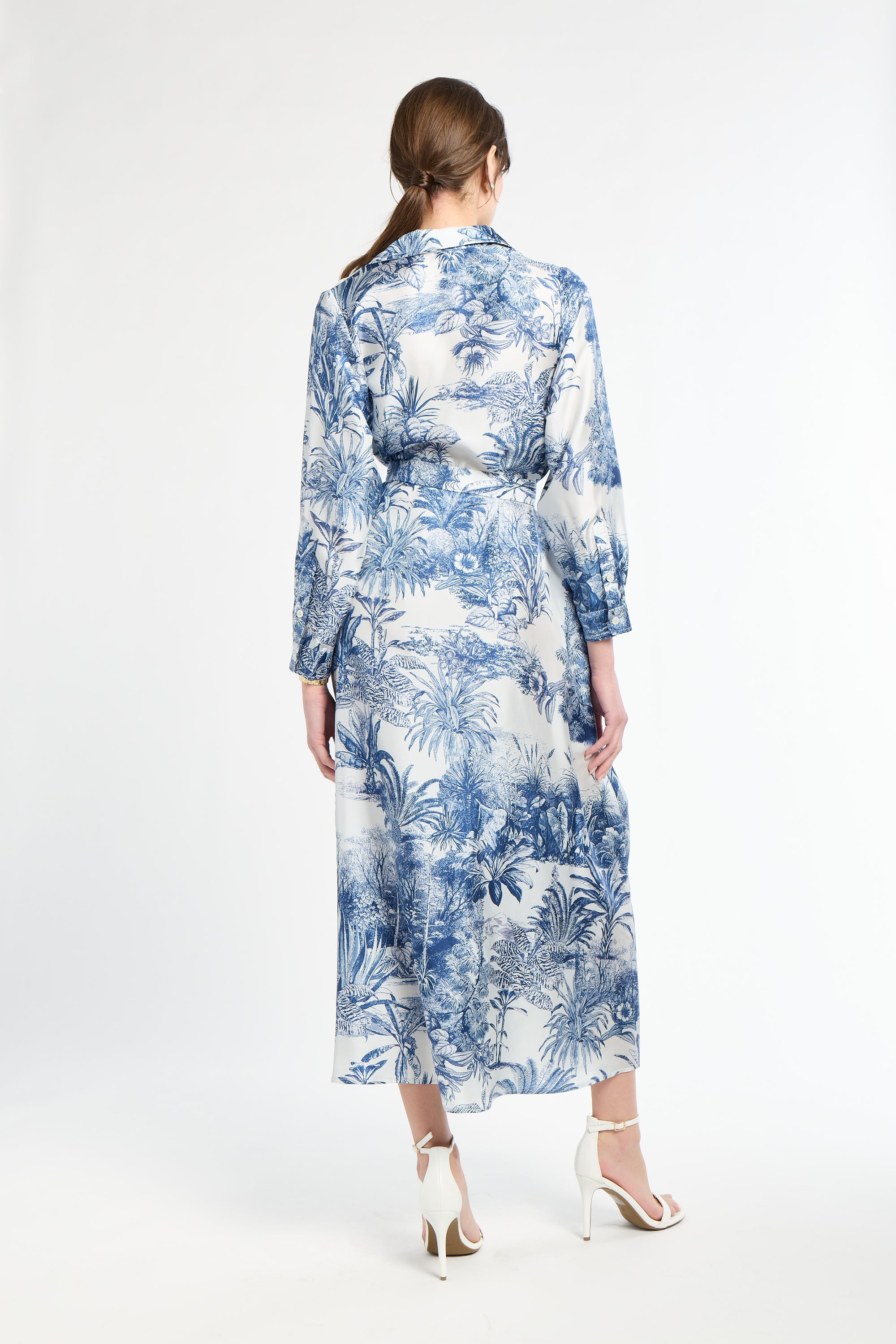 woman modeling a blue and white patterned maxi dress on a white backdrop
