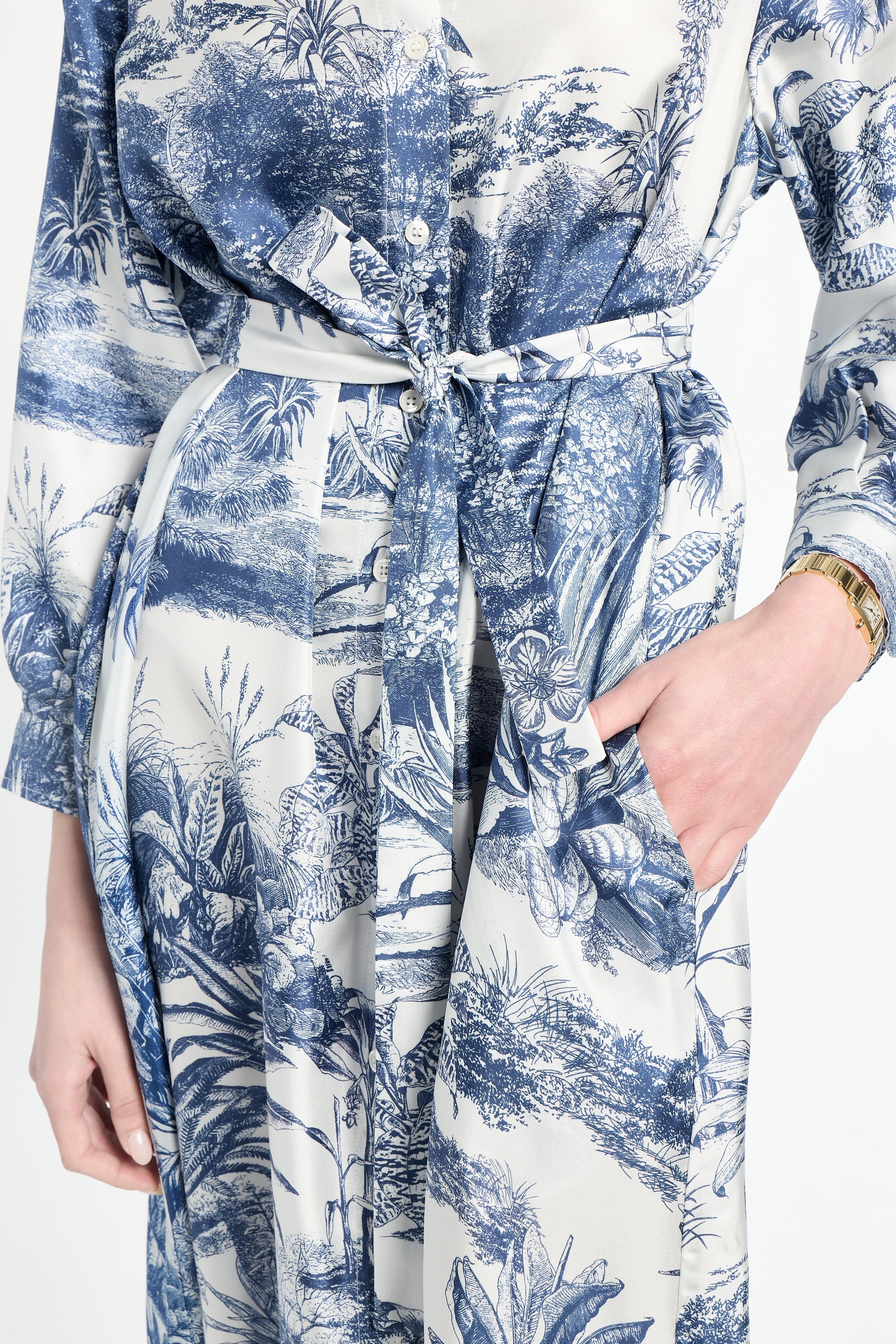 Blue and white floral patterned dress with a tie waist on a white background